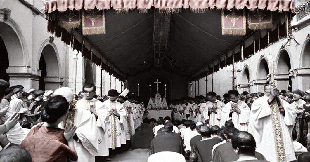 Traditional Catholic Eucharistic procession in Córdoba, Argentina, 1959. Clergy in Latin Mass vestments lead the faithful in solemn prayer under a canopy adorned with banners.